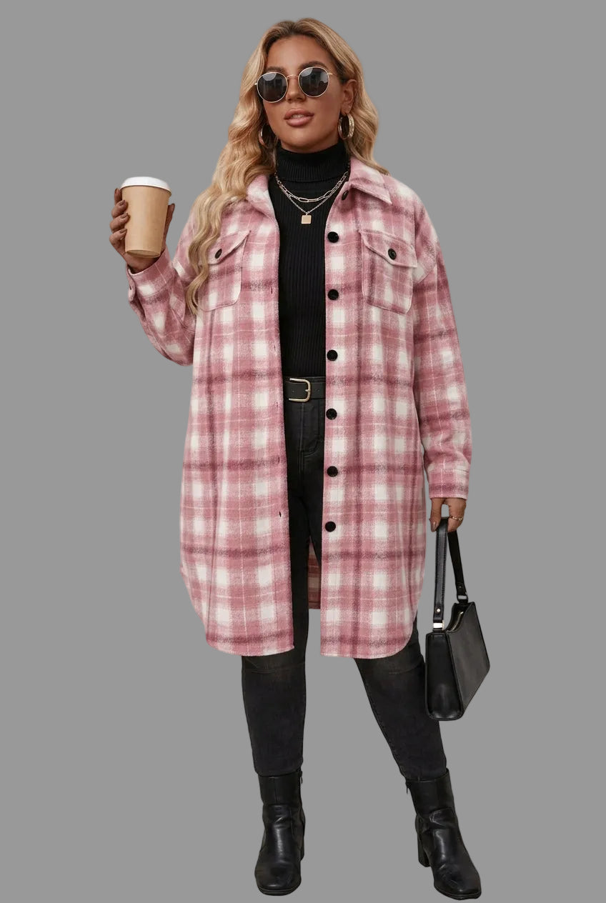 A woman models a pink and white plaid button-up coat over a black turtleneck and black pants, holding a handbag and a coffee cup against a plain background.