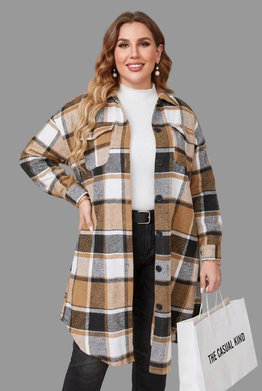 A woman models a long-line plaid coat in brown, beige, black, and white. She is wearing a white turtleneck, black jeans, and holding a shopping bag against a plain background.