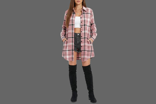 A woman wearing a pink, white, and black plaid button-up shirt over a white crop top and black denim shorts