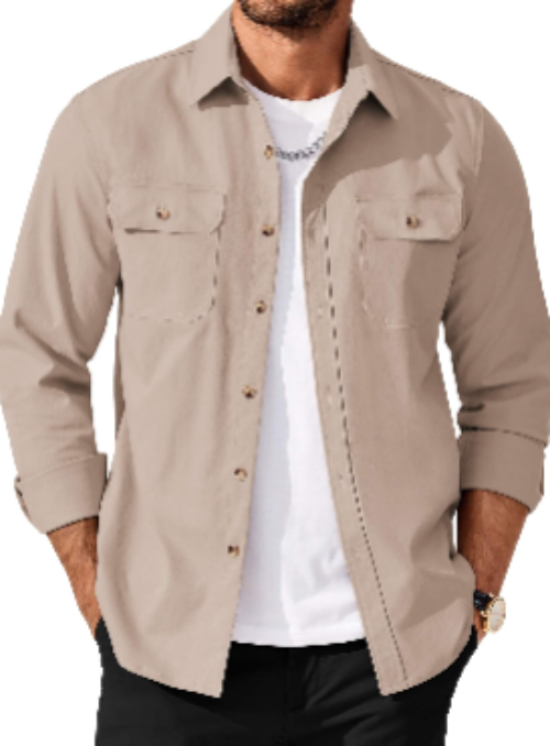 A man wearing a light beige long-sleeve button-up shirt over a white t-shirt and black pants, shown from the chin down against a plain white background.